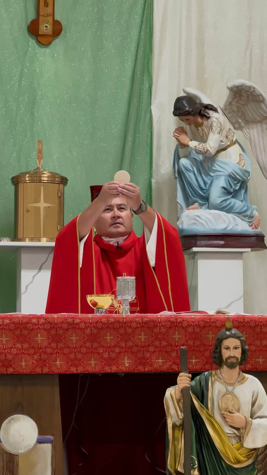 El sacerdote eleva la hostia consagrada durante la Misa en la Misión