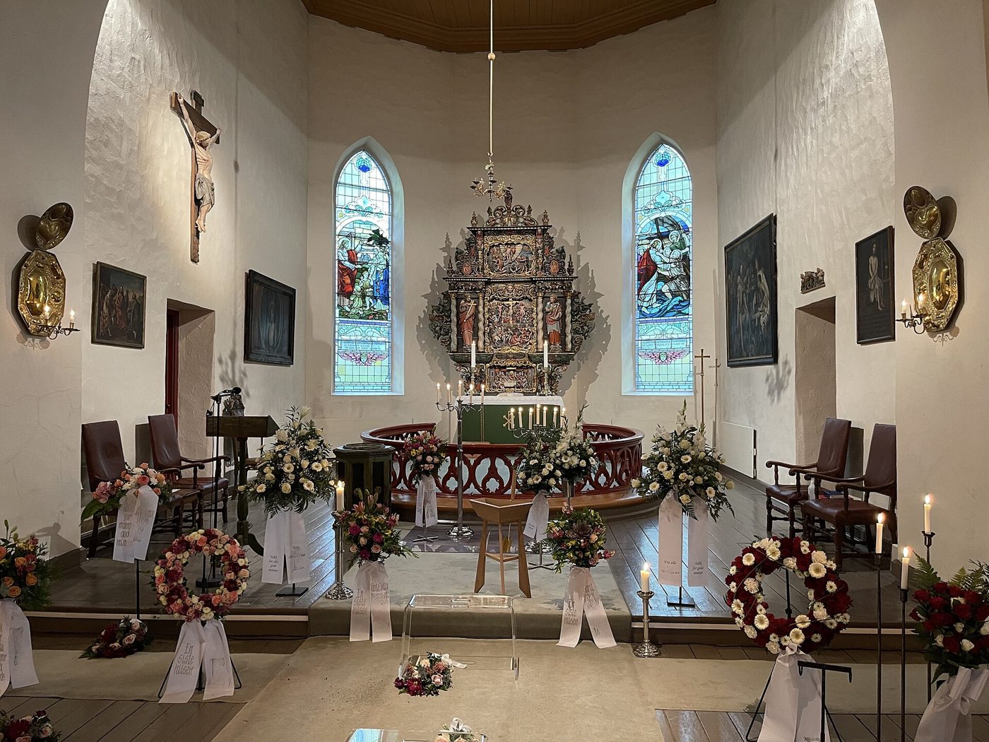 Church interior with flower wreaths and candles before the altar