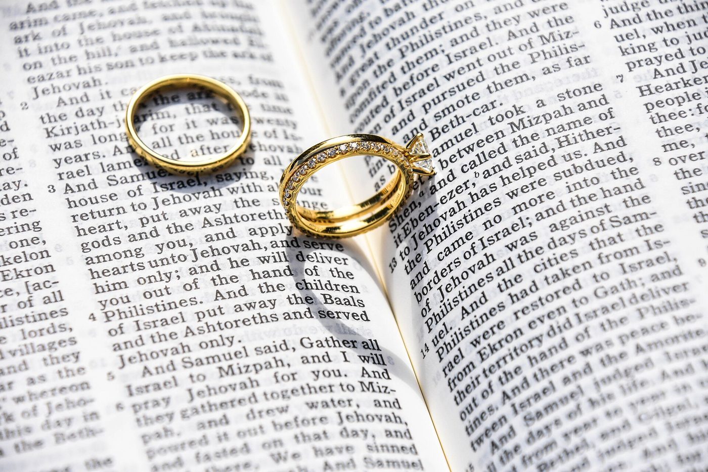 Two gold rings on an open Bible