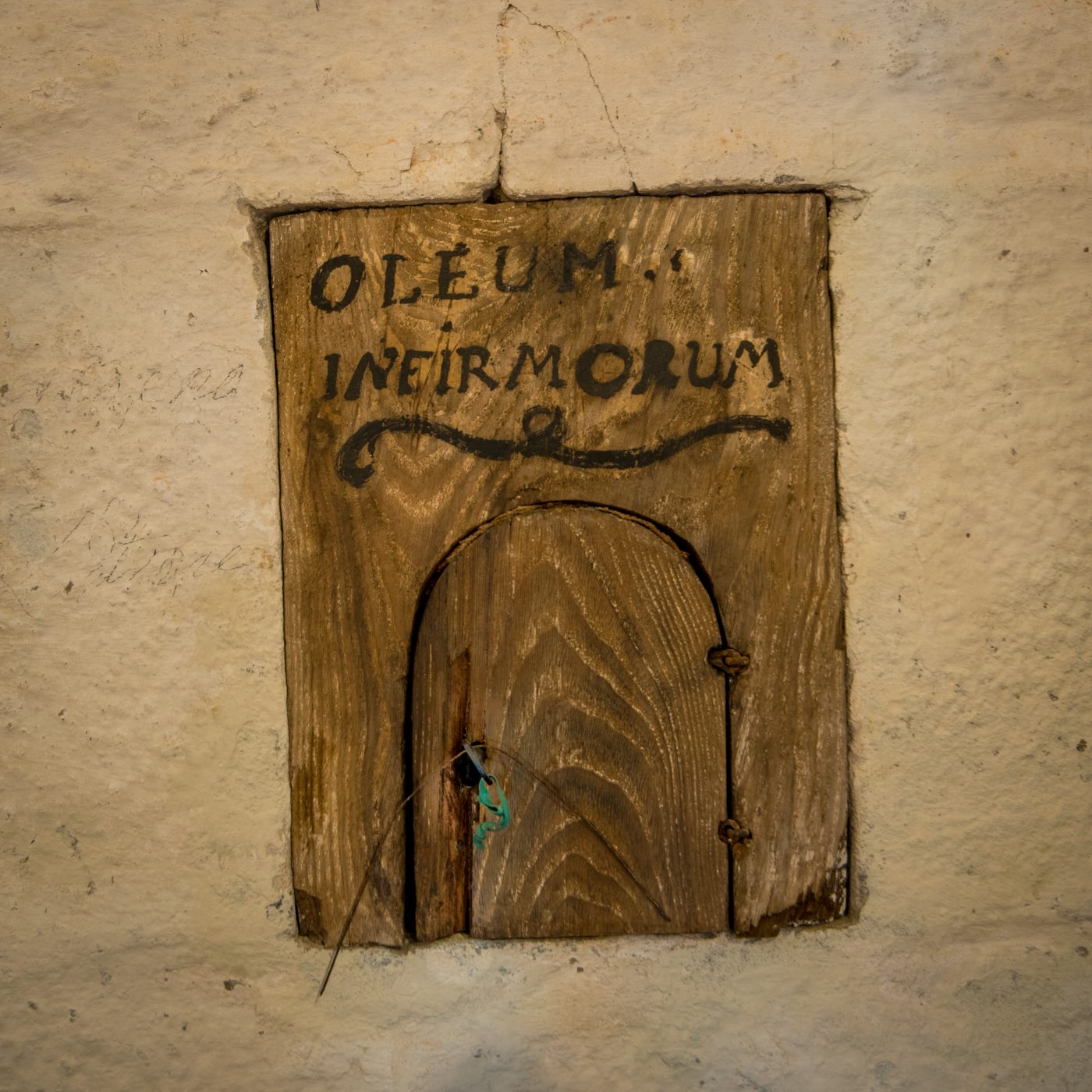 Wooden door inscribed "Oleum infirmorum", the oil of the sick